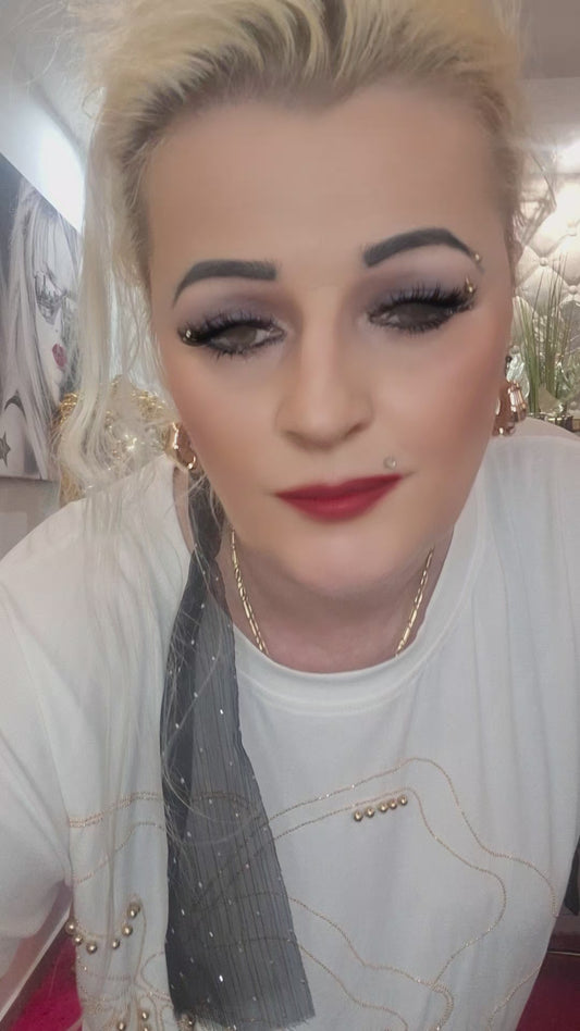Rozžiarte svoj outfit s týmto nádherným bielym tričkom, ktoré je zdobené oslnivými zlatými zirkónmi